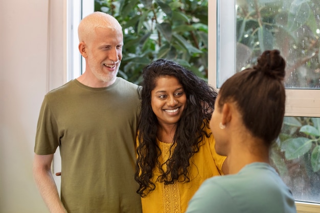 Three diverse individuals (a young woman, an elderly man, and a teenager) shown interacting with their AI pets on different devices. Each person displays a positive emotion (smiling, laughing) while engaging with their virtual companion.