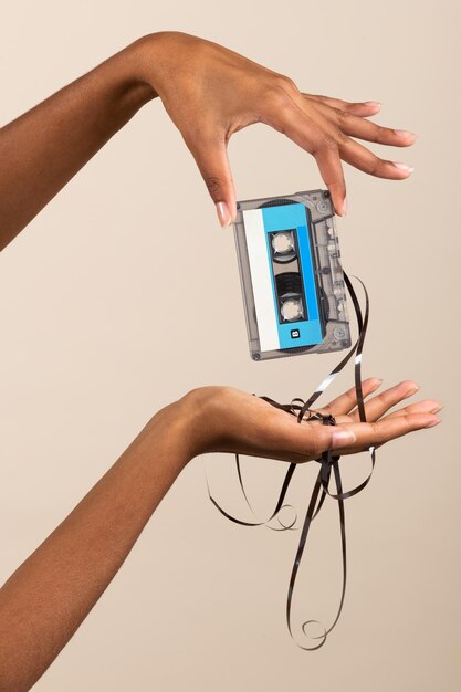A close-up shot of someone carefully repairing a vintage Sony Walkman. The person's hands are visible, and they are using small tools to work on the device's internal components. The focus is on the act of repair and restoration.