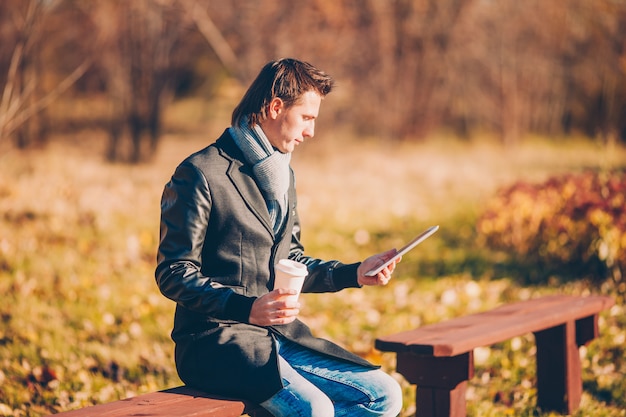 A person mindfully using a tablet while sitting in a park, illustrating a balanced approach to technology. The setting is relaxed, and the person's posture suggests intentional and purposeful engagement.