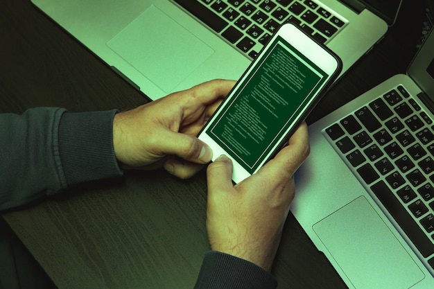 A smartphone displaying a multi-factor authentication code with a computer screen showing a login page in the background, emphasizing the importance of MFA.