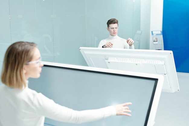 A modern hospital scene featuring AI-assisted diagnostics displayed on a screen, and a doctor consulting with a patient, demonstrating the integration of AI technology in healthcare for improved diagnosis and treatment.