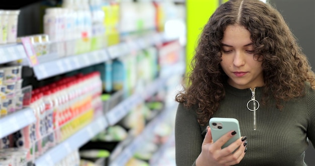 A person using a digital couponing app on their smartphone while shopping in a grocery store.