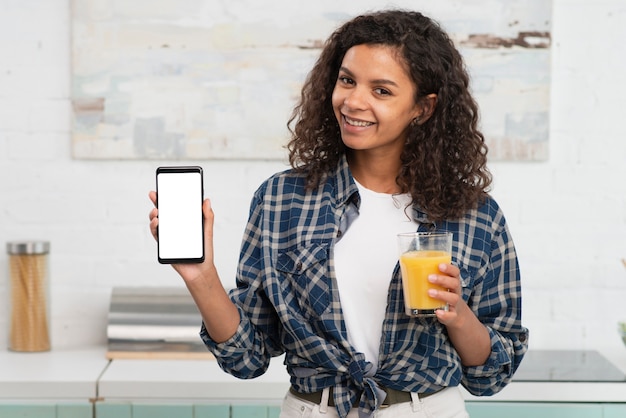 A person smiling and holding a smartphone, showcasing a mobile app interface with a 