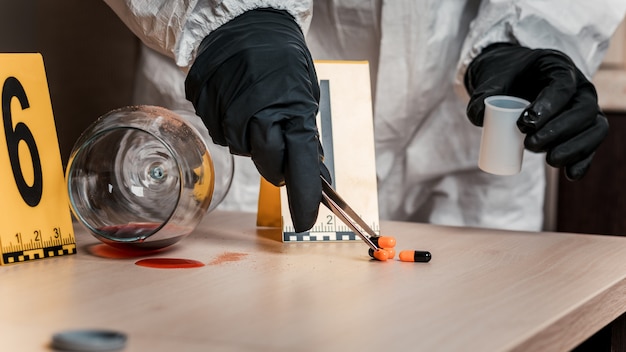 A forensic scientist in protective gear examining a charred room with specialized tools. Emphasis on the meticulous process of gathering evidence and documenting the scene to determine the real cause of fire.