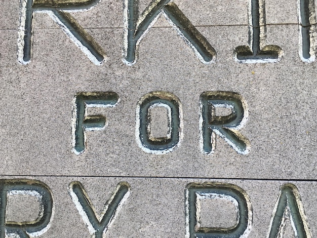 A close-up of one of the Georgia Guidestones' granite slabs, showcasing the engraved text in English. The weathered texture of the stone and the precise lettering are clearly visible, emphasizing the monument's durable construction and multilingual message.
