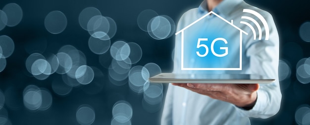 A tech-forward image illustrating 5G technology connecting a home. The image should show a 5G cell tower transmitting signals wirelessly to a modem inside the home, and devices like laptops, smart TVs, and tablets connected to the modem via Wi-Fi. The scene should emphasize speed and convenience.